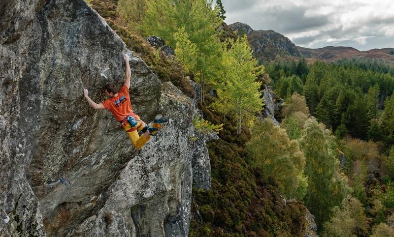 Climber in a t-shirt on natural rock Climber in a t-shirt on natural rock